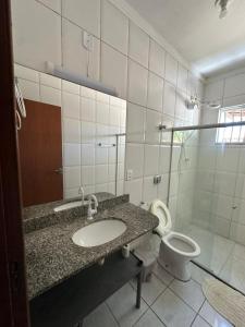 a bathroom with a sink and a toilet at Casa Fantástica in Guriri