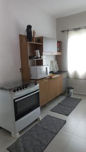 eine Küche mit Herd und Mikrowelle in der Unterkunft Apartamento caminho das thermas com AR condicionado in Piratuba + 7 Fotos
