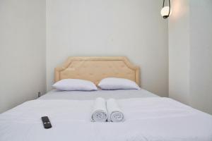 a bed with white sheets and two towels on it at Clarissa Guest House Cisarua Bandung in Sukaraja