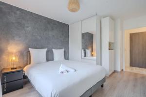 En eller flere senge i et værelse på Central and peaceful apartment 10 min Disney - 4P