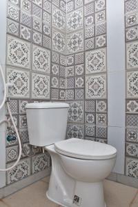 a white toilet in a bathroom with a tile wall at Clarissa Guest House Cisarua Bandung in Sukaraja