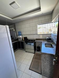 a kitchen with a sink and a counter top at Casa Fantástica in Guriri