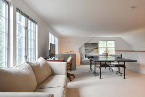 een woonkamer met een bank en een tafel bij Private pool 3 mins to Skaket Beach in Orleans