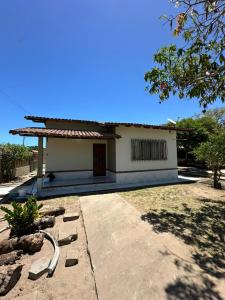 a small white house with a driveway at Casa Fantástica in Guriri +21 photos