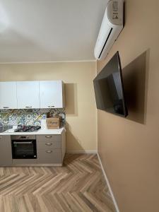 een keuken met een fornuis en een tv aan de muur bij Aubry Appartament in Praia a Mare