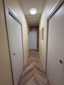 Een gang in een kantoor met twee deuren en houten vloeren. bij Aubry Appartament in Praia a Mare