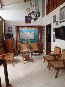 un soggiorno con sedie, tavolo e TV di Paviliun Omah Ndanu a Yogyakarta