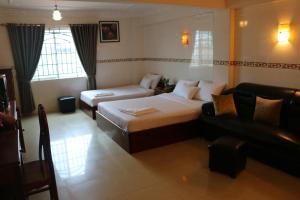 um quarto de hotel com uma cama e um sofá em Relax Guesthouse em Phnom Penh