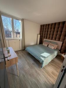 une chambre avec un lit et une grande fenêtre dans l'établissement Appartement hyper-centre Stella, à Dunkerque