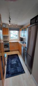 een keuken met een roestvrijstalen koelkast en een tapijt bij Great apartment with extreme views in Tromsø