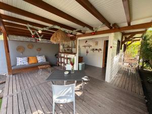 een patio met een tafel en een bank op een terras bij Bungalow la tipik in Saint-François +26 foto's