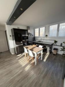 une cuisine avec une table et des chaises dans une pièce dans l'établissement Appartement hyper-centre Stella, à Dunkerque