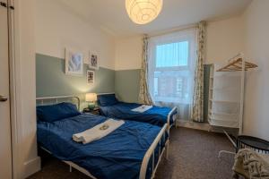 two beds in a small room with a window at The Salty Seagull in Scarborough