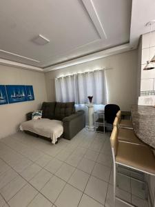 un salon avec un canapé et un lit dans l'établissement Casa Guriri Top - Piscina, Praia e Churrasqueira, à Guriri