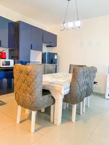 a dining room table and chairs with blue cabinets at Bella luxury homes in Mombasa