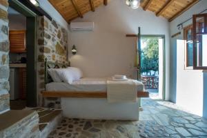 a bedroom with a bed and a stone wall at Casa Milos Aegean Suites in Alonnisos