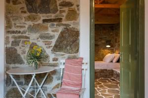 a room with a table and a stone wall at Casa Milos Aegean Suites in Alonnisos