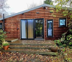 a log cabin with a porch and a deck at Pooh Corner in Hythe