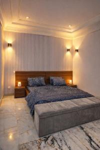 een slaapkamer met een groot bed en twee lampen bij CHROME Résidences Fidjrossè PLAGE in Cotonou +18 foto's