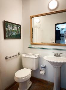 ein Badezimmer mit weißer Toilette und Waschbecken in der Unterkunft At Wind Chimes Boutique Hotel in San Juan