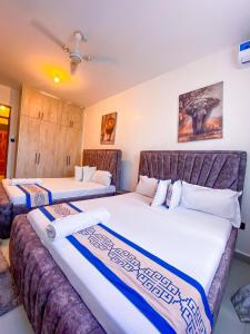 two beds in a hotel room with two mattresses at Bella luxury homes in Mombasa +40 photos