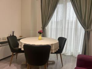 a dining room table with chairs and a vase of flowers on it at Cozy Appartament in Floreşti