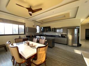 une cuisine et une salle à manger avec une table et des chaises dans l'établissement Chahat Villa, à Palampur