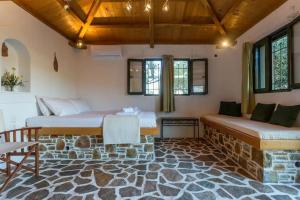 a room with two beds and a stone floor at Casa Milos Aegean Suites in Alonnisos