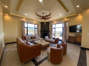 - un salon avec des canapés et un ventilateur de plafond dans l'établissement Chahat Villa, à Palampur