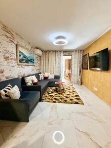 ein Wohnzimmer mit einem blauen Sofa und einer Ziegelwand in der Unterkunft Apartment with terrace and pool, Los Cristianos in Los Cristianos