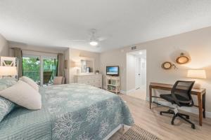 ein Schlafzimmer mit einem Bett, einem Schreibtisch und einem Computer in der Unterkunft Island Beach Club #220B in Sanibel + 43 Fotos