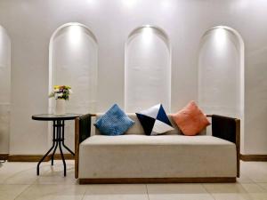 a couch with pillows on it with a table at MaMa Hostel CNX in Chiang Mai +28 photos