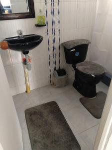 a bathroom with a black toilet and a sink at Apartamento cerca del aeropuerto in Bogotá +21 photos