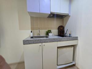 een keuken met witte kasten en een spoelbak bij Budget Studio Al Reem Island in Abu Dhabi +16 foto's
