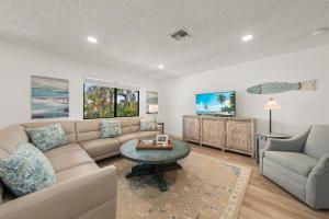 a living room with a couch and a table and a tv at Blind Pass #E209 in Sanibel