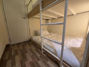 een slaapkamer met 2 stapelbedden met witte lakens bij Budget Studio Al Reem Island in Abu Dhabi