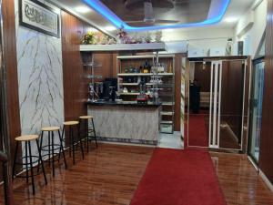 a bar in a restaurant with stools and a red carpet at Prime Star Hotel in Karachi