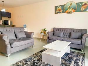 a living room with two couches and a table at Bella luxury homes in Mombasa