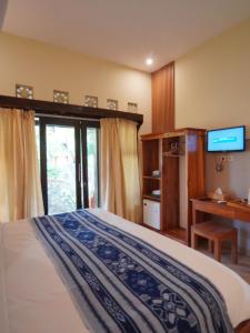 a bedroom with a bed and a desk and a television at Salili Bungalow in Gili Islands +56 photos