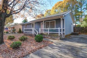 a blue house with a porch and a fence at Stylish 4BR Home - Modern & Bright Interior in Charlotte