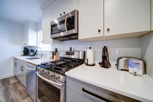 a kitchen with a stove and a microwave at Stylish 4BR Home - Modern & Bright Interior in Charlotte