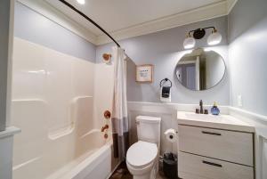 a bathroom with a toilet and a sink and a mirror at Stylish 4BR Home - Modern & Bright Interior in Charlotte