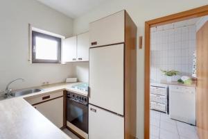 a kitchen with a white refrigerator and a sink at Ferienwohnung PfalzRide in Annweiler am Trifels