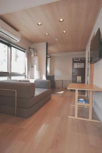 een woonkamer met een bank en een tafel bij AURA YUZAWA Apartment Hotel - 1Bedroom Apartment with Living Dining Kitchen Sleeps 2 to 4, Bedroom with 2-Double Bed, Living Room with 1-Sofa Bed in Yuzawa