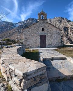 une ancienne église en pierre avec une montagne en arrière-plan dans l'établissement Casa Bella Centre de Corsica, à Corte