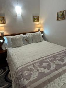 une chambre avec un grand lit avec des draps et des oreillers blancs dans l'établissement Casa Bella Centre de Corsica, à Corte