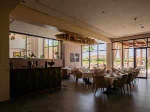SUMAHAN SUITES & SPA في مراكش: غرفة طعام مع طاولات وكراسي ونوافذ