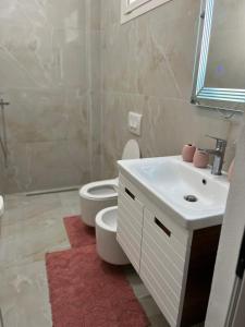 een badkamer met een wit toilet en een wastafel bij ApartHotel Sea & Back view studios in Durrës