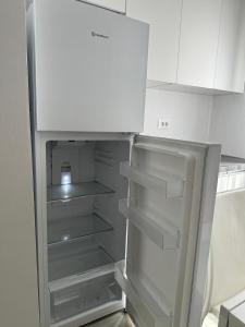 een lege koelkast met de deur open in een keuken bij ApartHotel Sea & Back view studios in Durrës