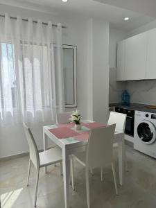 een witte keuken met een tafel en witte stoelen bij ApartHotel Sea & Back view studios in Durrës +35 foto's